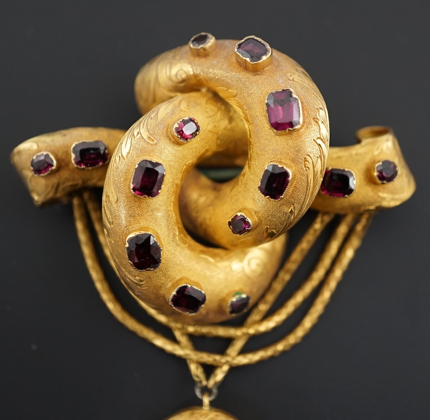 A Victorian textured gold and garnet cluster set drop 'knot' brooch